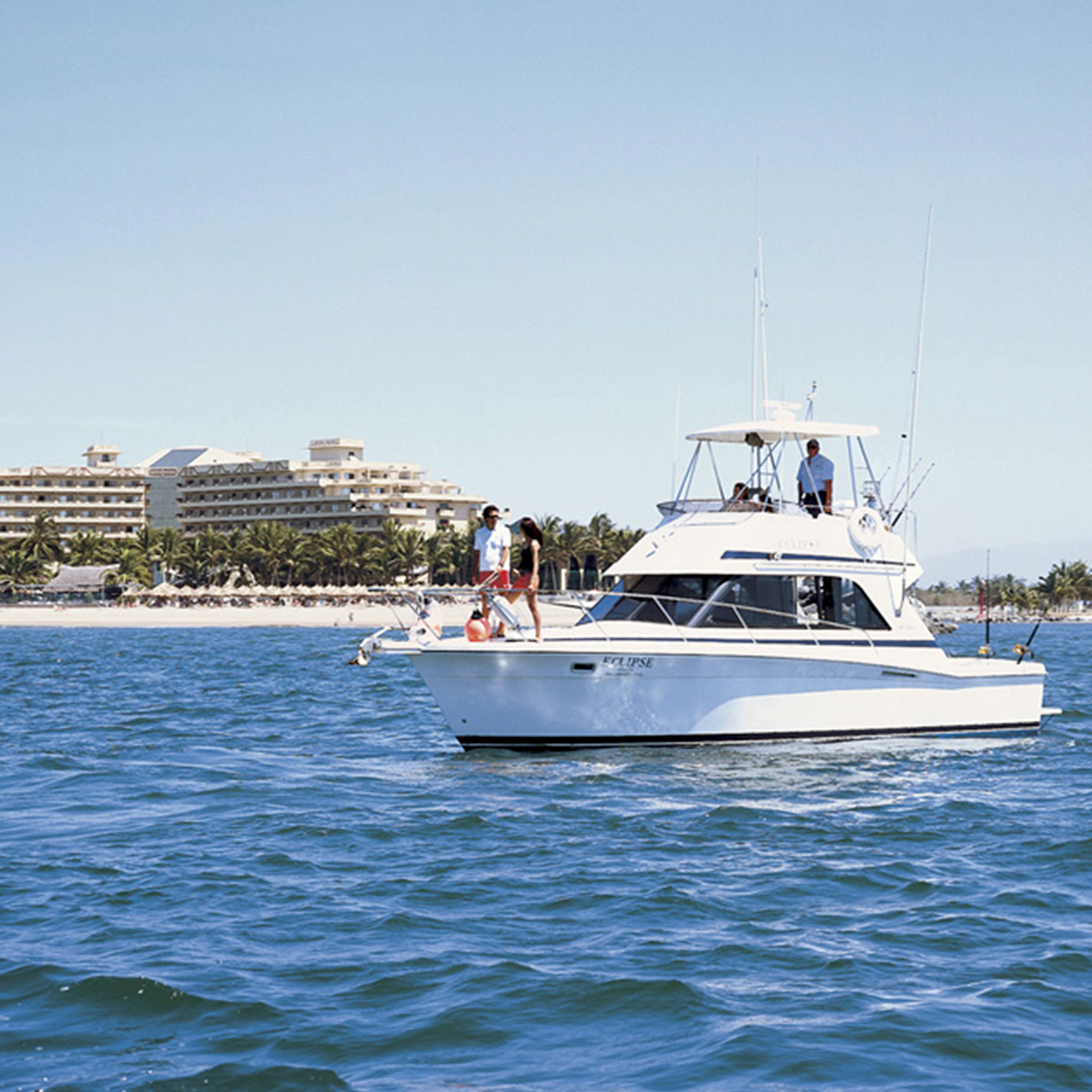 A white yacht with a cabin and a covered deck, sailing on calm waters.