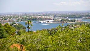A coastal cityscape with a river, buildings, and greenery. - Mercure Sydney St Leonards (Greenwich)