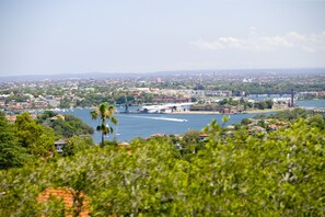 A coastal cityscape with a river, buildings, and greenery. - Mercure Sydney St Leonards (Greenwich)