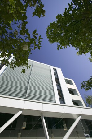 A modern building with a large glass facade and a white exterior. - Mercure Sydney St Leonards (Greenwich)