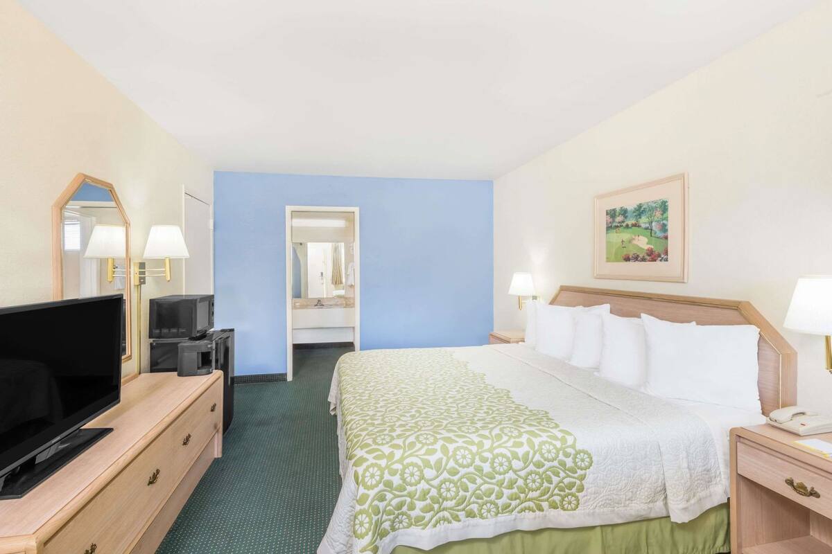 Une chambre d’hôtel équipée d’un lit, d’une télévision, d’un bureau et d’un miroir.