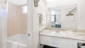 A modern bathroom with a bathtub, a sink, and a mirror.