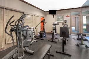 A gym with various exercise equipment, including treadmills, stationary bikes, and weight machines.