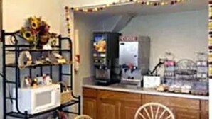 Een keuken met houten kastjes, een magnetron en een koffiezetapparaat.
