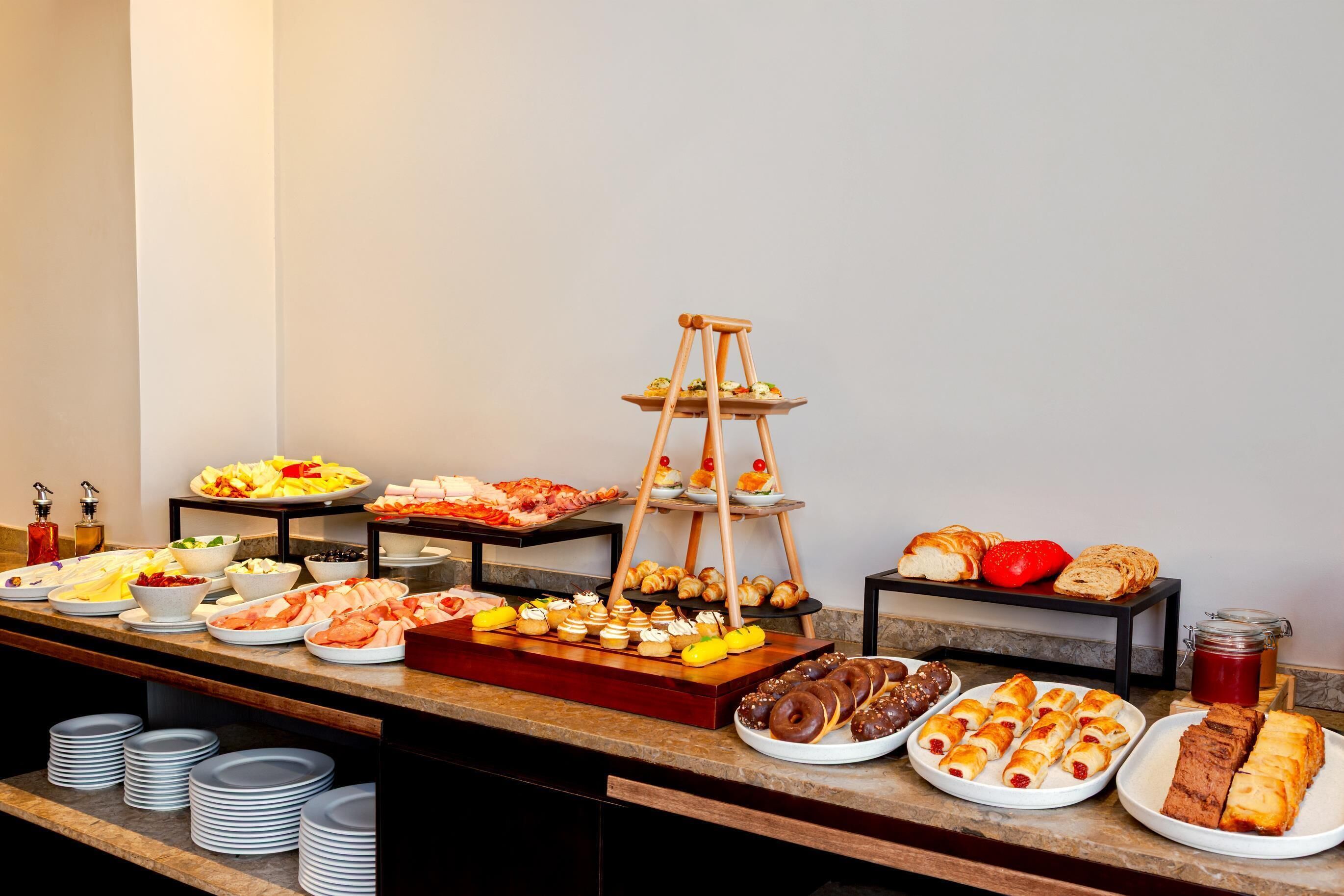 A buffet with various food items and a tiered dessert stand.