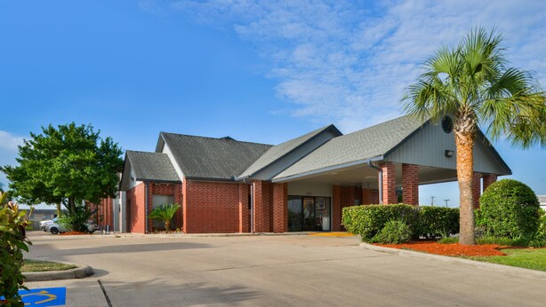 A two-story building with a brick facade and a covered entrance. - Americas Best Value Inn Pasadena Houston (Pasadena)