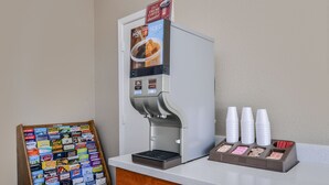 A coffee machine with a digital display and a coffee cup dispenser. - Americas Best Value Inn Pasadena Houston (Pasadena)