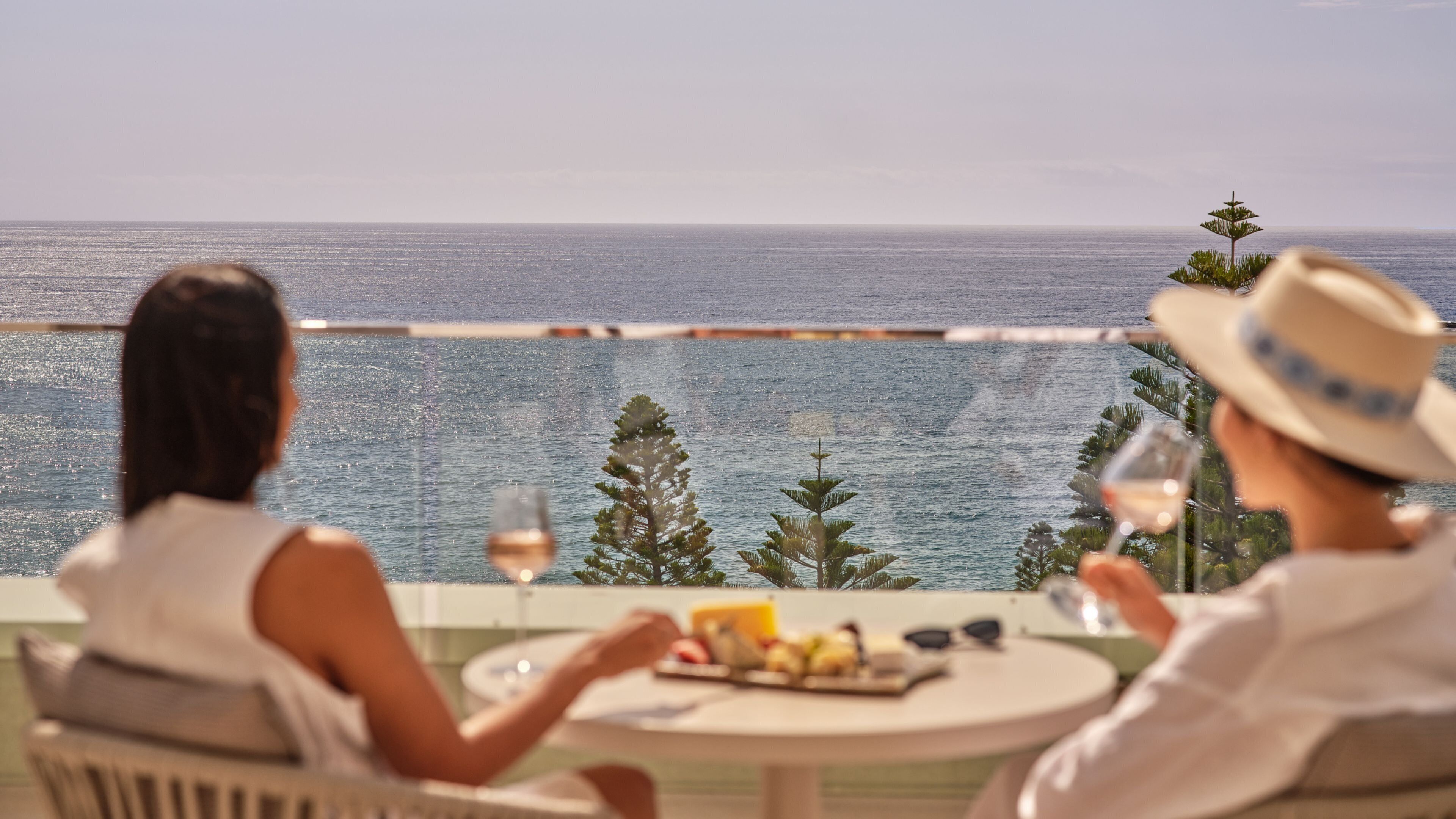Two people dining at a table with a view of the sea.
