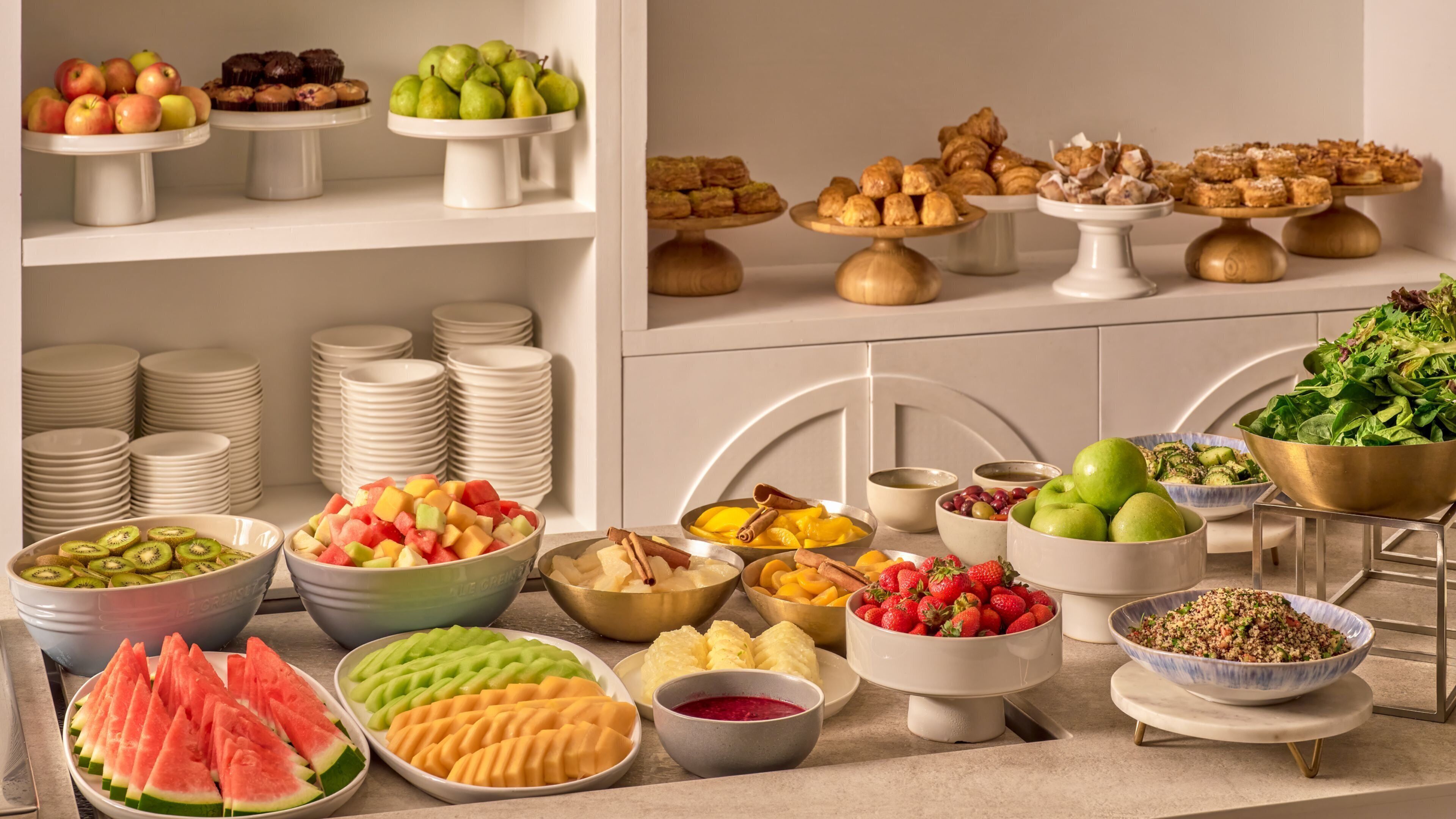 A buffet with various fruits, vegetables, and desserts.