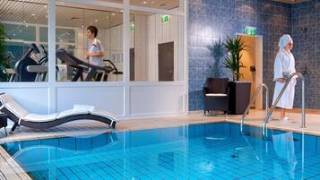 Una piscina techada, sillones reclinables de piscina