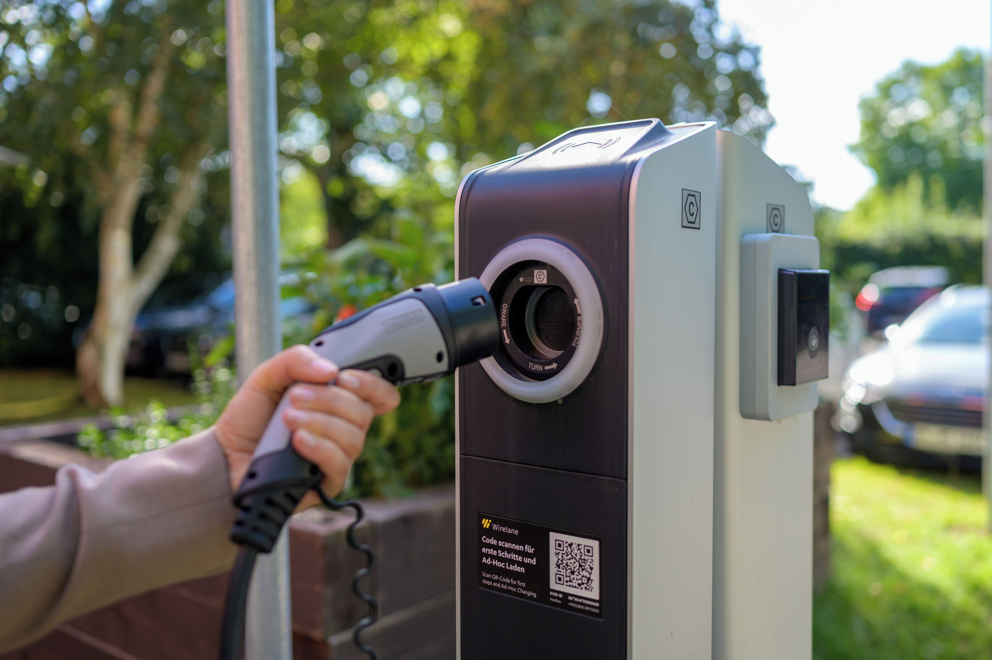 A parking meter with a QR code and instructions for scanning a code for the first parking step and Ad-Hoc charging.