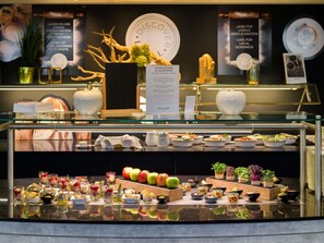 A buffet area with various food items and a menu sign. - Mercure Hotel Köln West (Cologne)