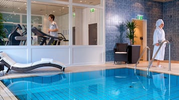 Una piscina techada, sillones reclinables de piscina