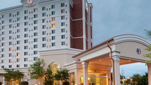 A large, multi-story hotel with a prominent entrance and a well-lit facade. - DoubleTree by Hilton Greensboro (Greensboro)