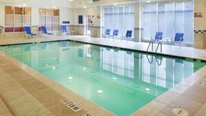 An indoor swimming pool with clear water, blue lounge chairs, and a no diving sign. - DoubleTree by Hilton Greensboro (Greensboro)