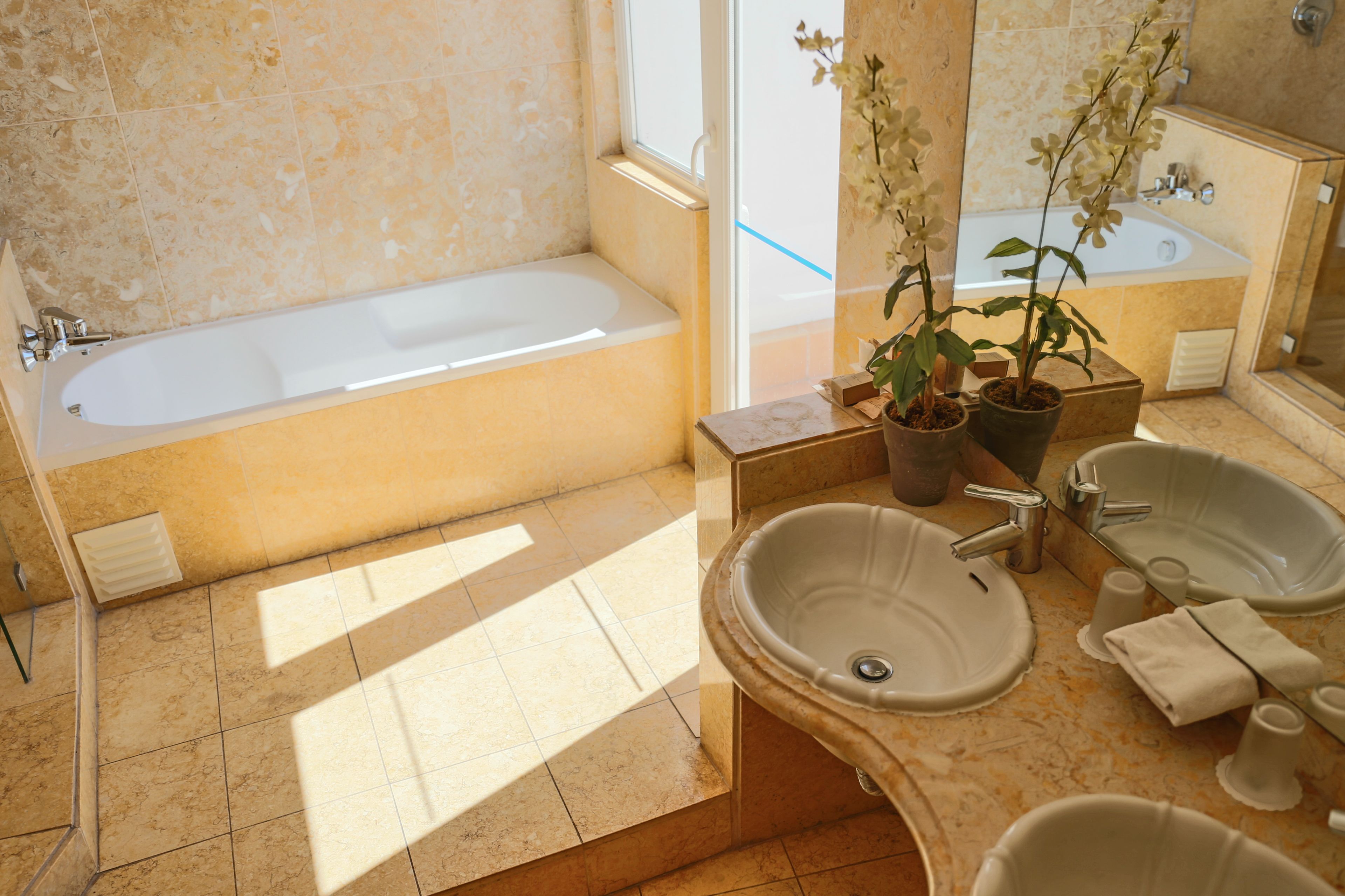 A bathroom with a bathtub, two sinks, and a large mirror.