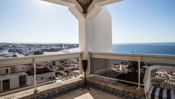Un balcón con vistas al mar y al paisaje urbano.
