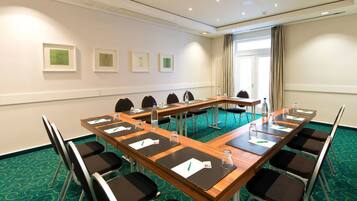 A conference room with a long table, chairs, and framed pictures on the wall.