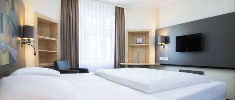 A hotel room with a large bed, a desk, a chair, a flat-screen TV, and a painting on the wall.