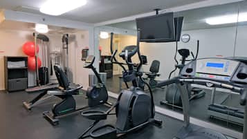 A gym with various exercise equipment, including treadmills, elliptical machines, and weight machines.