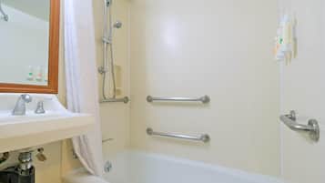 A bathroom with a bathtub, a sink, a mirror, and a shower.