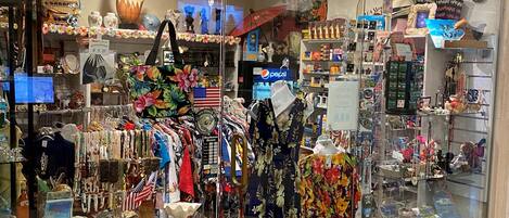 A store with glass display cases filled with various souvenirs, jewelry, and clothing items.
