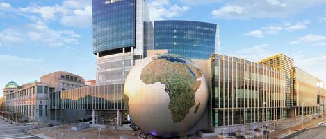 A modern building with a large glass globe sculpture in front.