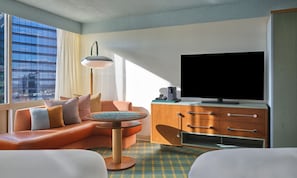 A modern hotel room with a leather sofa, a small round table, a television, and a cabinet. - Hotel Indigo Raleigh Downtown by IHG (Raleigh)