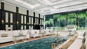 A spacious room with a large, clear blue pool, white sofas, and a backdrop of hanging greenery. - InterContinental Bahrain by IHG (Manama)