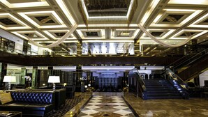 A spacious lobby with a checkered floor, a central staircase, and a modern chandelier. - InterContinental Bahrain by IHG (Manama)