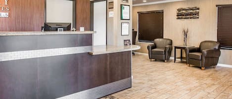 A reception area with a counter, seating area, and framed certificates on the wall.