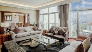 A spacious living room with a large window, a sofa set, a coffee table, and a lamp. - Sheraton Kampala Hotel (Kampala)