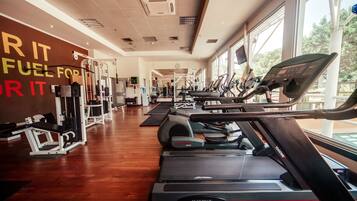 A gym with treadmills, weight machines, and a motivational wall.