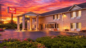 A brick building with a covered entrance and a sign for EconoLodge. - Econo Lodge Inn & Suites Fairview Heights - St. Louis (Fairview Heights)