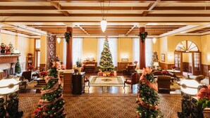 A spacious lobby with a large Christmas tree, comfortable seating, and a piano. - Hotel Colorado (Glenwood Springs)