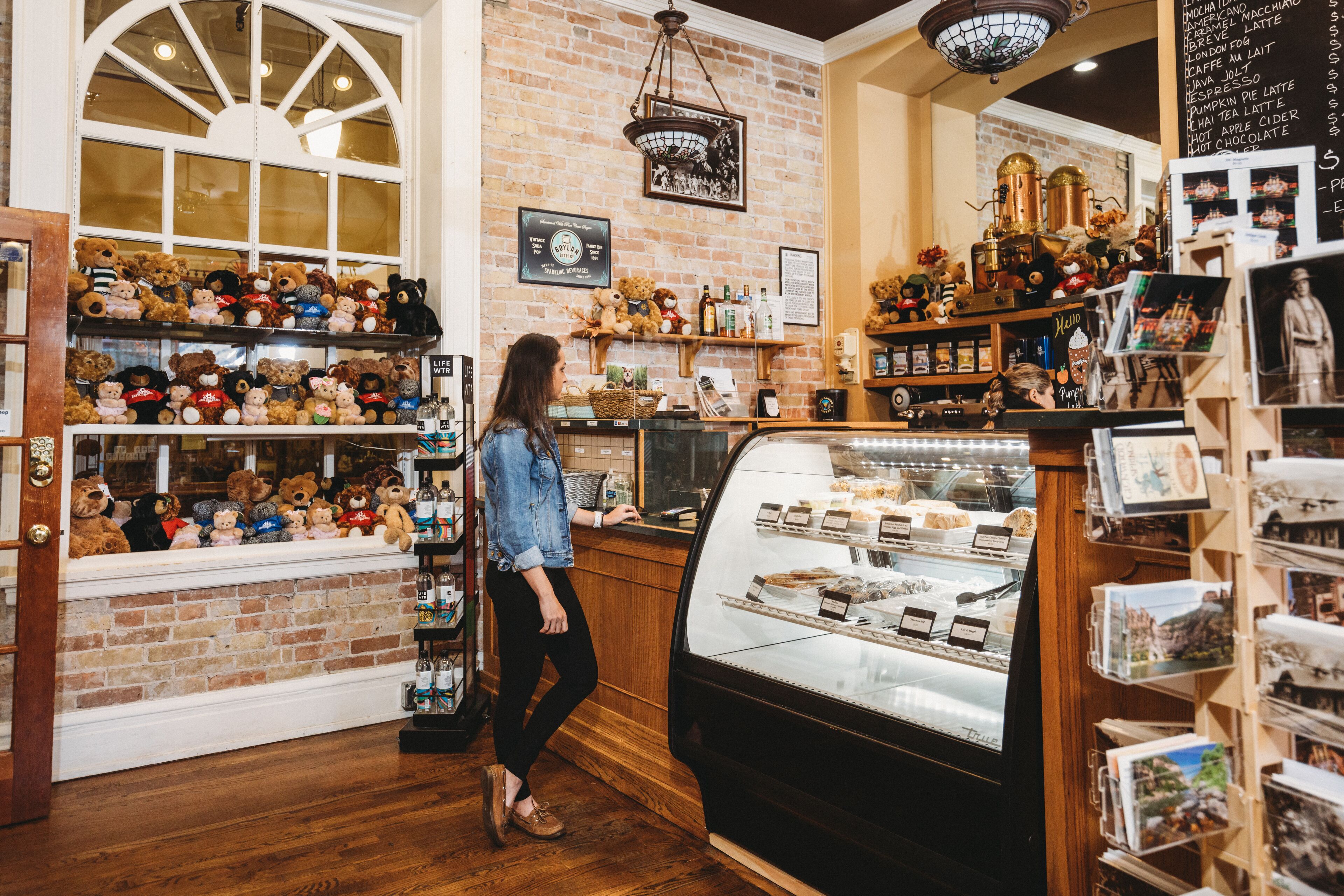 A bakery with a display case of pastries and shelves of baked goods.