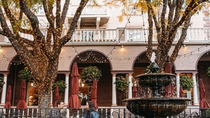 A courtyard with a fountain, outdoor seating, and trees. - Hotel Colorado (Glenwood Springs)