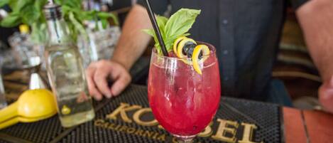 Een cocktail met rietje en garnering op een barmat met de tekst 'California Champagne'.