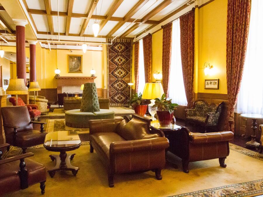 Um hall tradicional com sofás de couro, uma mesa de centro e um tapete estampado.