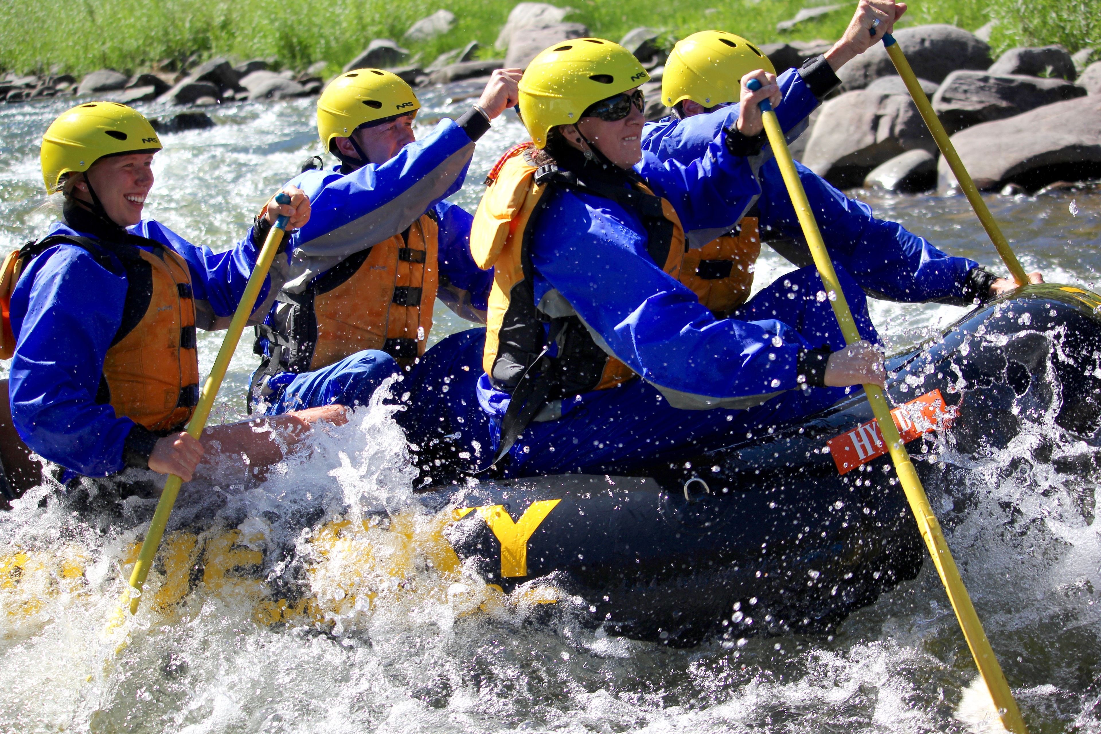 A group of people in a raft navigating through a river.