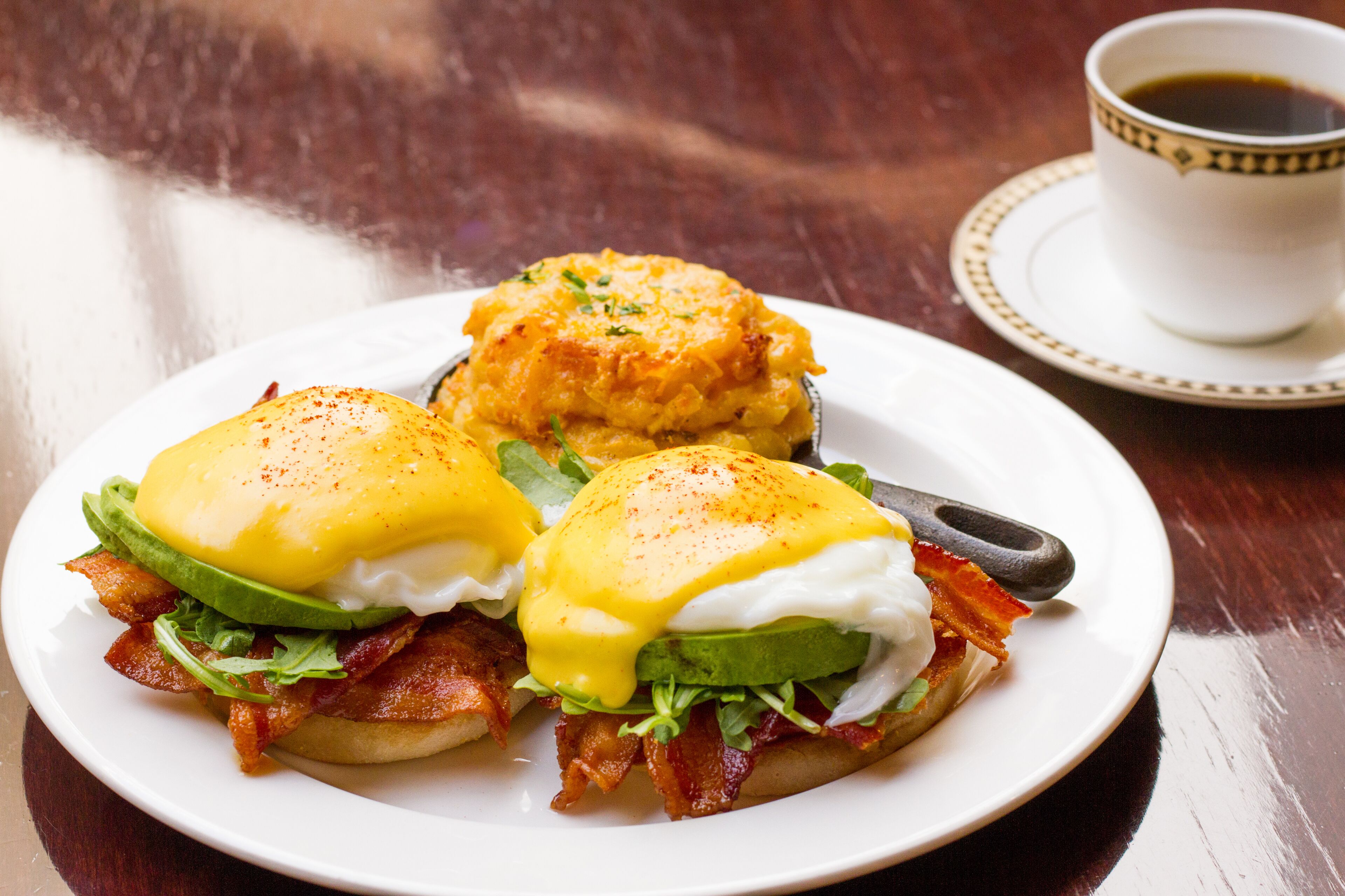Prato de pequeno-almoço com ovos Benedict e batatas palha.