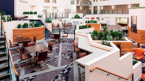 A multi-level indoor space with seating areas, staircases, and greenery.