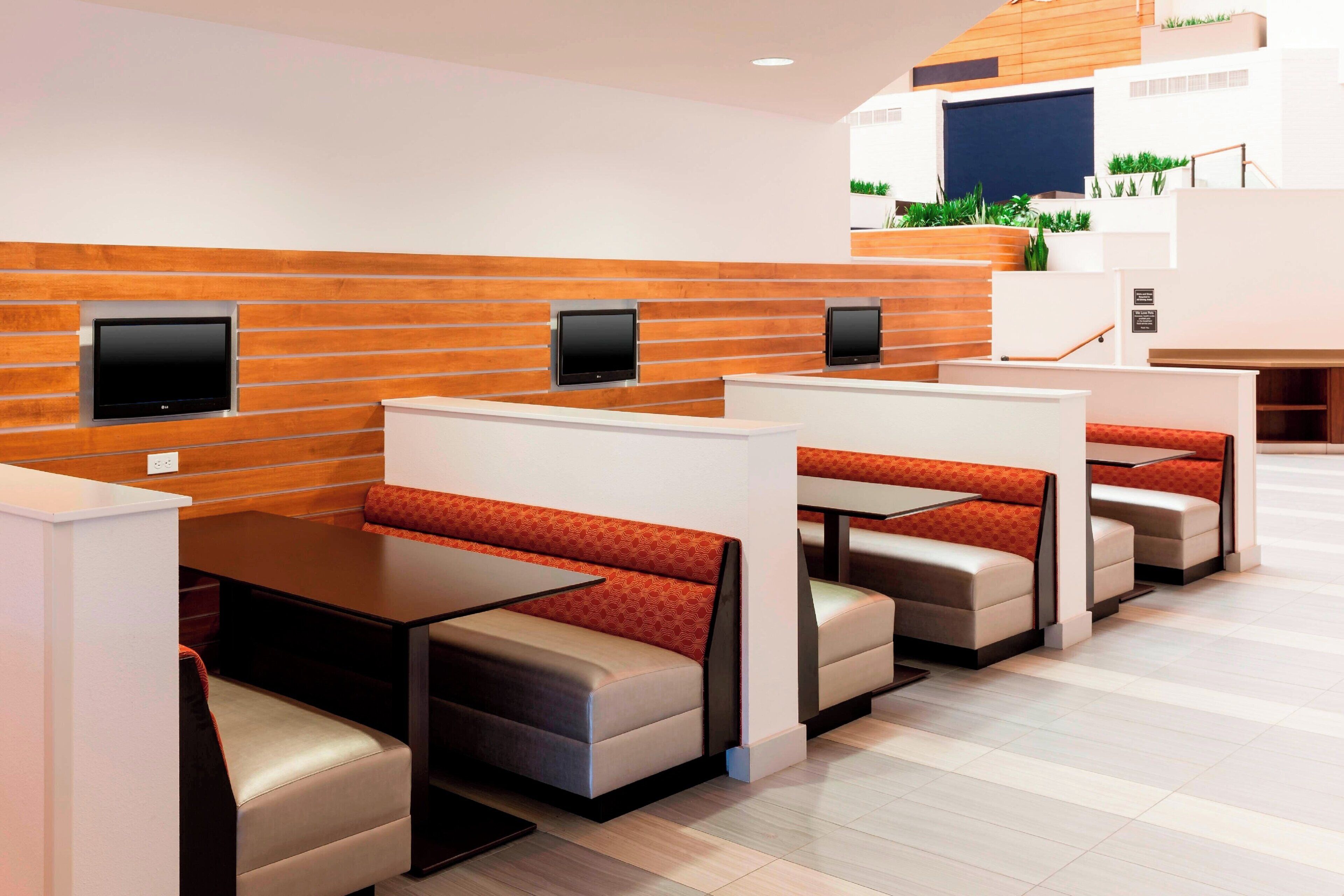 Un restaurant moderne avec des banquettes et un mur décoratif en bois.