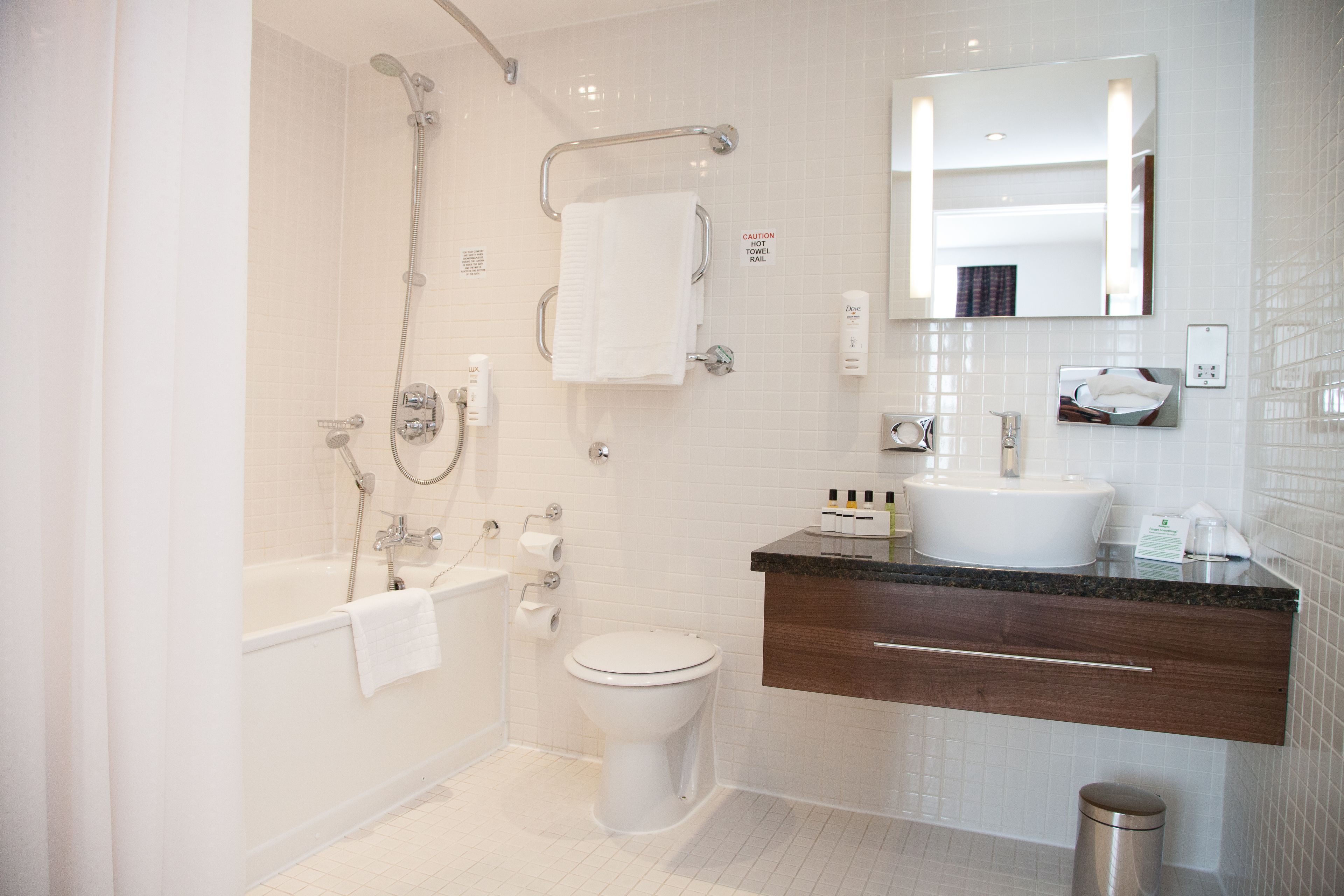 A modern bathroom with a bathtub, toilet, and sink.