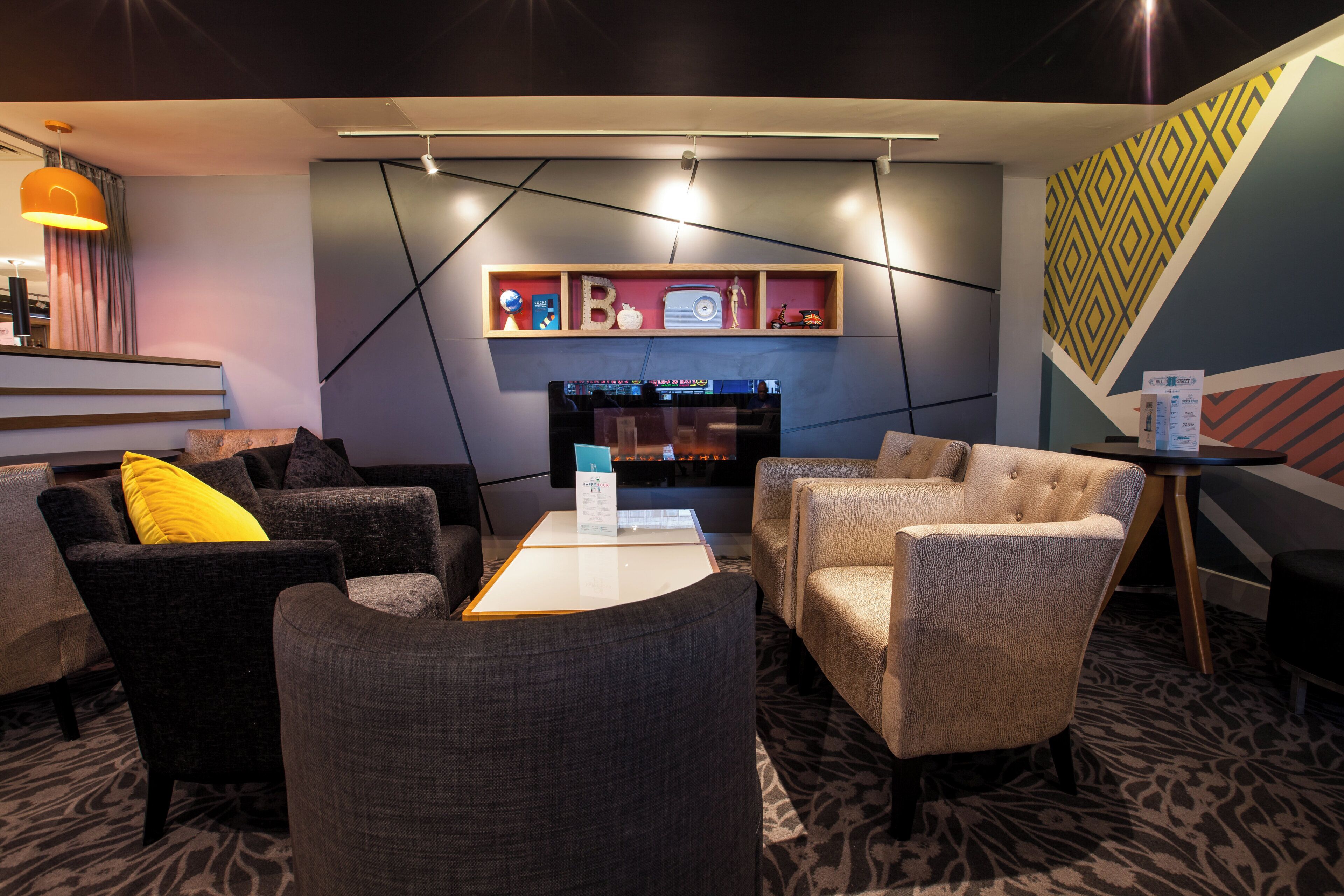 A modern lounge area with sofas, a coffee table, and a fireplace.
