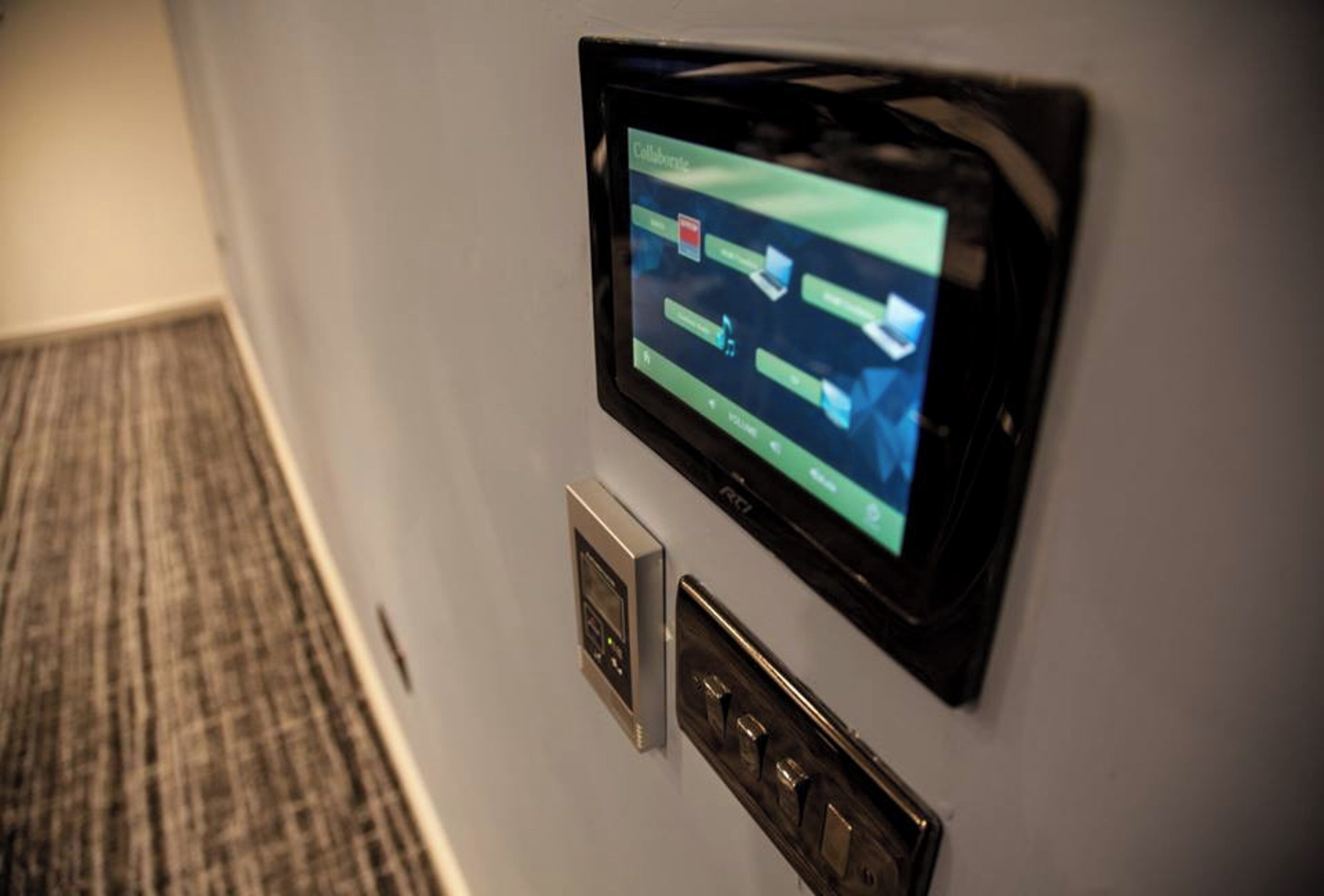 A wall-mounted control panel with a screen displaying a map and a keypad.