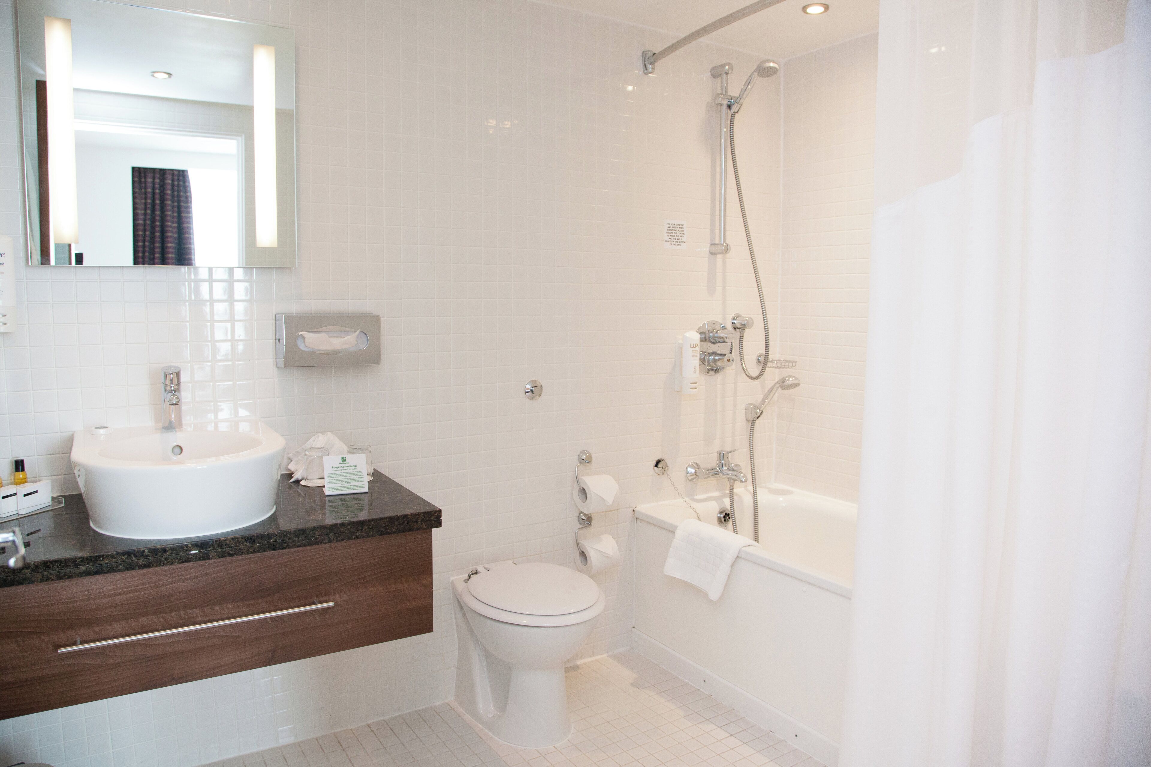 Et stilfuldt badeværelse med vask, toilet og brusebad.