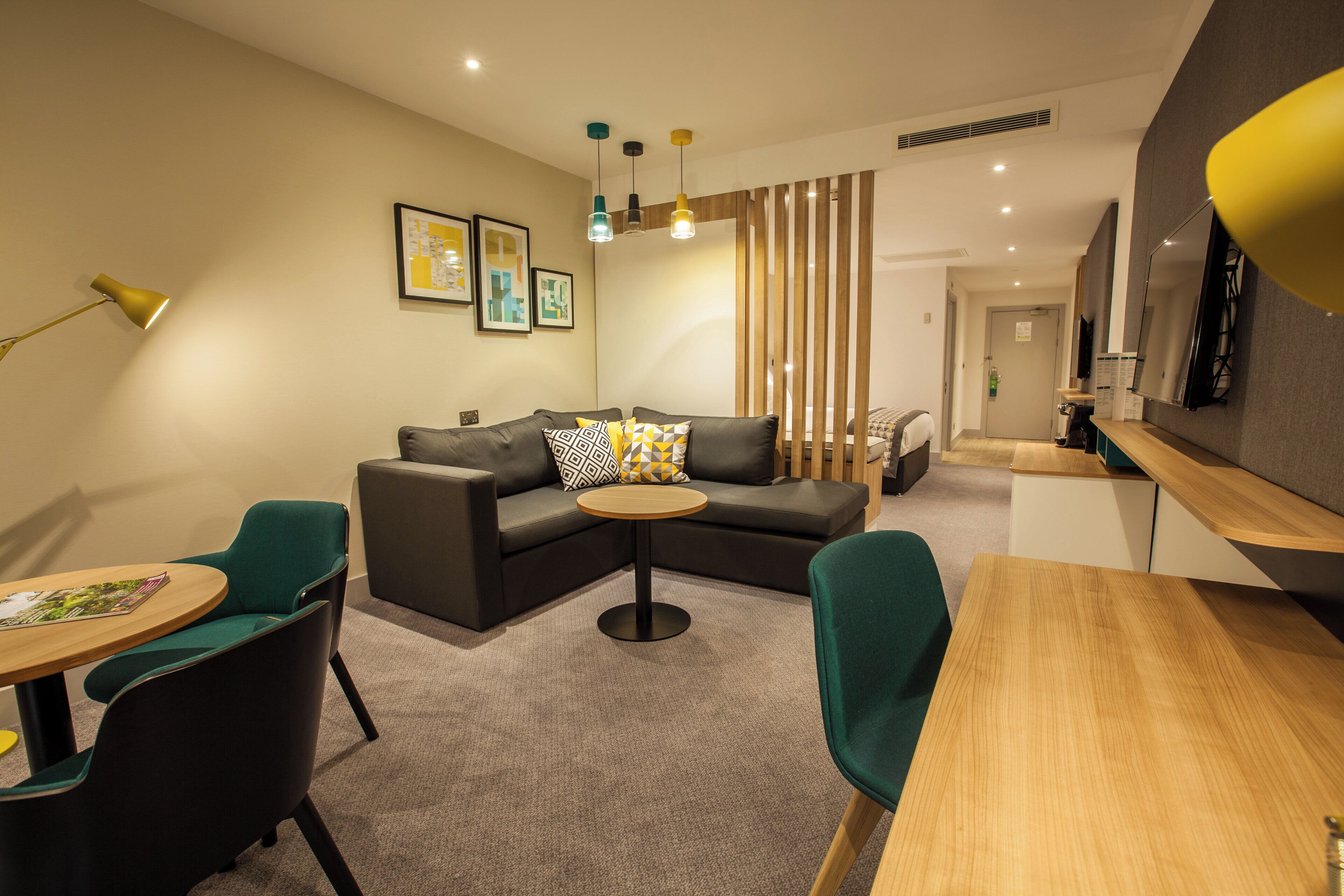 A modern living room with a sectional sofa, a round coffee table, and a dining area with a wooden table.