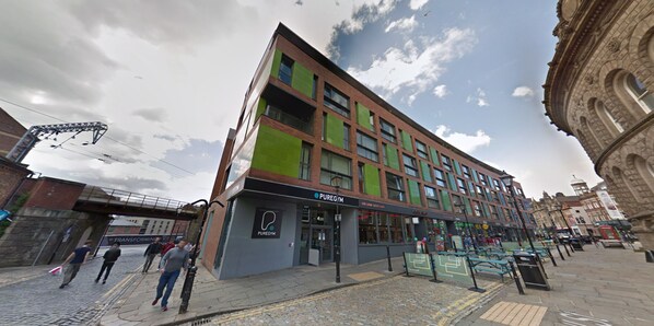 A multi-story building with a modern design, featuring a storefront with a sign that reads "PUREGYM." - 42 The Calls (Leeds)