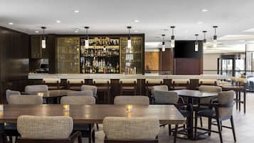 A bar area with multiple seating options, a well-stocked bar, and a modern interior design.